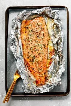 a piece of salmon on tin foil with chopsticks