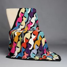 a colorful blanket sitting on top of a white chair