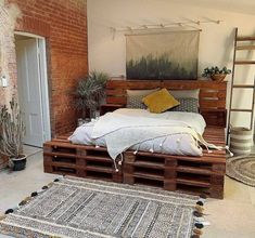 a bed made out of wooden pallets in a room with brick walls and flooring