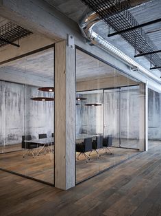 an empty conference room with glass walls and wooden floors