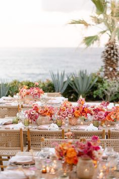 an outdoor dining area with tables and chairs set up for a formal dinner by the ocean