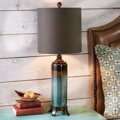 a lamp sitting on top of a wooden table next to a chair and bookend