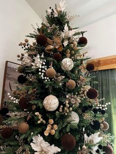 a decorated christmas tree with white and brown ornaments