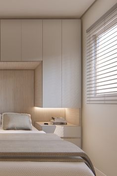 a bed sitting in a bedroom next to a window with blinds on the windowsill