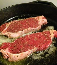 two raw meats are cooking in a skillet