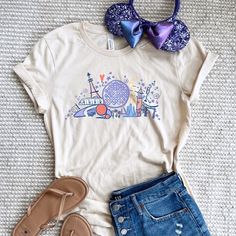 a white shirt with a blue bow tie and some denim shorts on a bed next to shoes