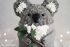 a cake made to look like a koala bear with flowers on its head and neck