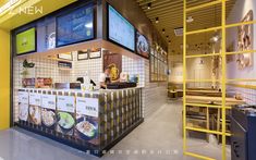 the interior of a fast food restaurant with menus on the wall and yellow scaffolding