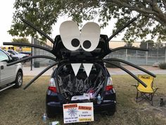 a car that has been decorated to look like a spider with large eyes and legs