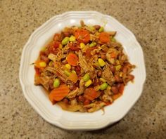 a white bowl filled with food on top of a table