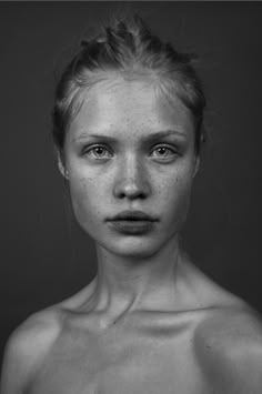 a black and white photo of a woman with freckles on her face