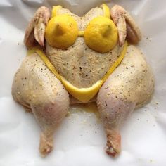 a chicken with two lemons on it's head and eyes, sitting in a white paper bag