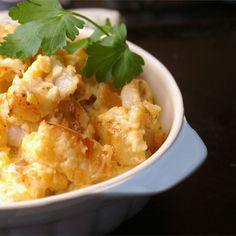 a white bowl filled with food and garnished with cilantro leaves on top