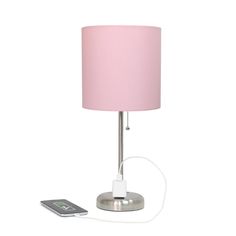 a pink lamp and remote control on a white background with a phone plugged in