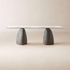 the table is made out of concrete and has an oval top with two triangular shaped bases