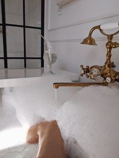 a bathtub filled with foam and water next to a faucet