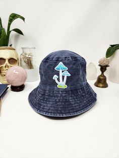 Welcome to Eternal Luna Shop! This mushroom hat is made with a 100% cotton bucket hat and a mushroom patch. The patch sits in the center and the hat is a muted navy blue color. The patch showcases three blue mushrooms in grass.  Measurements: 23.125 inches ( 58.74 cm) around the inside, and the inner band has an adjustable tie to make it tighter. Brim is 2.5 inches (6.35 cm) in length. Didn't find what you were looking for? Click here to see the rest of the shop! https://www.etsy.com/shop/sarahslittlecottage Bucket Hat Mushrooms, Vintage Blue Bucket Hat With Short Brim, Handmade Blue Bucket Hat One Size, Retro Blue Bucket Hat, Fun Blue Bucket Hat, Blue Mushrooms, Mushroom Patch, Cotton Bucket Hat, Patch Hats