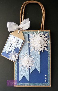 a blue and white bag with snowflakes on it, tied to a string