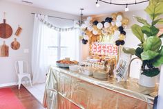 a buffet table with balloons and decorations on the wall behind it in a party setting