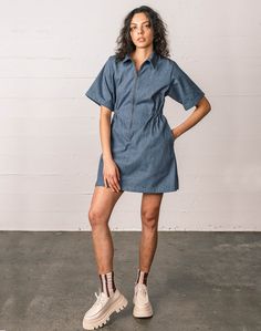 Dresses can be functional too. Meet our Utility Dress. Made in Guatemala with Upcycled Denim. Featuring oversized sleeves, our signature cinched waist, and a flattering oversized skirt. BONUS: giant pockets for all of your stuff. Model Notes Norma is wearing a size Small. Bust: 31.5 / Waist: 27 / Hips: 38 / Height: 5'11 Tam is wearing a size XL. Bust: 44 / Waist: 38 / Hips: 48 / Height: 5'8 Details - Runs true to size. - 100% Upcycled Denim - Pre-washed and pre-shrunk. Please note that denim wil Relaxed Fit Chambray Dresses In Medium Wash, Chambray Short Sleeve Dress With Pockets, Short Sleeve Chambray Dresses With Pockets, Denim Blue Dress With Pockets And Relaxed Fit, Relaxed Fit Chambray Dress With Pockets, Denim Blue Relaxed Fit Chambray Dress, Denim Blue Chambray Short Sleeve Dress, Denim Dress With Relaxed Fit And Short Sleeves, Short Sleeve Denim Blue Dress For Daywear