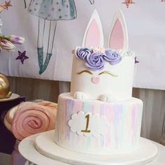 there is a cake that has been decorated with bunny ears and flowers on the top