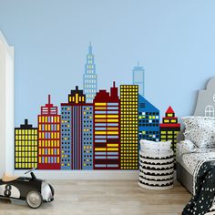 a child's bedroom with a city skyline wall decal on the wall and a toy car next to it