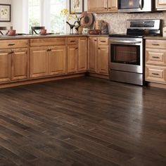 a kitchen with wood floors and stainless steel appliances