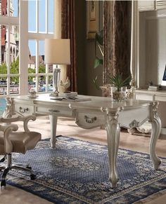 an elegant white desk and chair in front of a large window