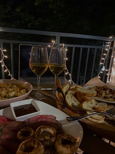 a table topped with plates of food and glasses of wine