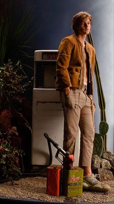 a man standing in front of an oven next to a cactus and a canister