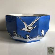 a blue and white bowl with birds painted on it