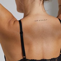 the back of a woman's bra with words written on her upper arm and chest