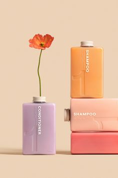 three different colored cans with a flower in them