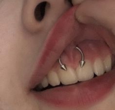 a close up of a person's mouth with piercings on it