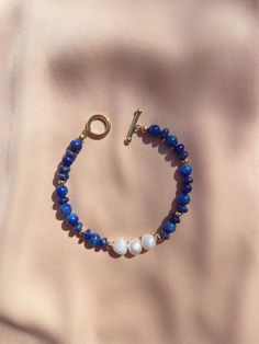 "The Maya Bracelet + Genuine Freshwater Baroque Pearls + Lapis Lazuli Beads + 14k Gold-filled beads + 14k Gold-filled toggle clasp Length: ~7\" * All pieces are handcrafted to order in Brooklyn, New York * Pieces may differ slightly from the images shown due to natural variation in the raw materials" Adjustable Hand-strung Blue Pearl Bracelet, Elegant Blue Bracelets With Polished Beads, Blue Pearl Bracelet With Gemstone Beads As A Gift, Blue Pearl Bracelet With Gemstone Beads For Gift, Elegant Handmade Lapis Lazuli Bracelets, Elegant Handmade Blue Pearl Bracelet, Blue Pearl Bracelet With Natural Stones, Elegant Blue Adjustable Pearl Bracelet, Handmade Elegant Blue Pearl Bracelet