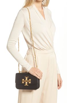 A bold logo medallion makes a gleaming statement on a finely grained leather handbag furnished with a pull-through strap for shoulder or crossbody carry. Magnetic-snap flap closure Pull-through chain strap Interior zip and slip pockets Structured silhouette with flat base for stability Leather Imported Travel Crossbody Shoulder Bag With Gold-tone Logo Plaque, Chic Travel Shoulder Bag With Gold-tone Logo Plaque, Chic Gold-tone Logo Plaque Shoulder Bag For Travel, Elegant Travel Shoulder Bag With Gold-tone Logo Plaque, Classic Shoulder Bag With Gold-tone Logo For Everyday Luxury, Timeless Gold Bags With Gold-tone Logo Plaque, Elegant Crossbody Shoulder Bag With Gold-tone Logo, Timeless Gold Shoulder Bag With Logo Plaque, Timeless Gold Shoulder Bag With Gold-tone Logo