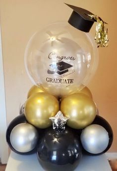 a graduation cake made out of balloons and other items in the shape of a graduate's cap