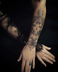 a woman's arm with tattoos on it and her hand holding the other arm