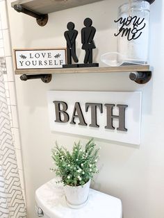 a bathroom with two shelves above the toilet and a potted plant next to it