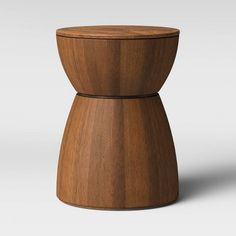 a small wooden stool sitting on top of a white floor