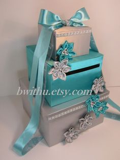 three boxes stacked on top of each other with ribbons and bows around the bottom one