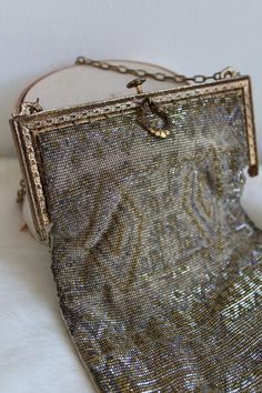 This is such a special antique purse. It is intricately beaded with silver tone and gold tone beads. The beaded of the purse has a natural patina that add to its charm. The metal hardware of the purse is in an antiqued gold tone and filigree design. The purse opens to reveal a peach tone lining. The lining is very old and shows its age. It is very delicate and could be easily replaced. The pocket of the purse is still intact as is its mirror. The purse is so special and with the lining needs to Antique Beaded Rectangular Evening Bag, Vintage Silver Handmade Bag, Vintage Handmade Silver Bag, Handmade Victorian Gold Bags, Antique Beaded Evening Bag For Formal Events, Vintage Silver Embellished Evening Bag, Antique Silver Bags For Vintage Events, Traditional Silver Beaded Bag, Antique Beaded Bags For Vintage Events