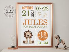 a cross stitch pattern for a baby's birth is shown in front of a wooden frame