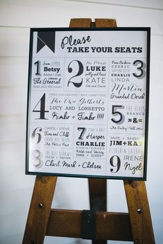 a wooden easel with a sign on it that says please take your seats