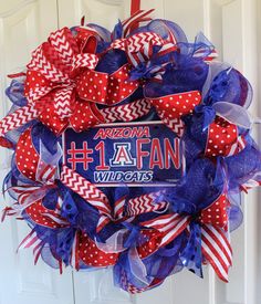 a red, white and blue wreath with the words arizona 1 fan on it in front of a door