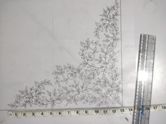 a ruler is next to a piece of paper with flowers on it