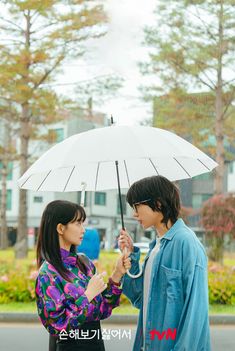 two people standing under an umbrella in the rain