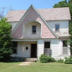 an old white house with a pink roof