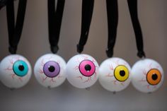 five different colored eyeballs hanging from black cords