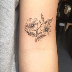 a black and white flower tattoo on the arm